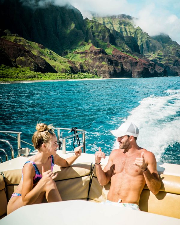Girl and Guy on a Boat in Tropical Waters with Mountains